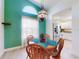 Cozy dining area with a charming light fixture, large window, and adjacent updated kitchen at 1307 Wayne Ave, New Smyrna Beach, FL 32168