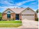 Well-maintained single-story home boasts a brick front, green lawn, and spacious two-car garage at 1307 Wayne Ave, New Smyrna Beach, FL 32168