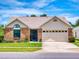 Charming single-story home featuring a brick facade, manicured lawn, and an attached two-car garage at 1307 Wayne Ave, New Smyrna Beach, FL 32168
