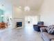 Bright living room with a fireplace, elegant chandelier, and neutral tile flooring throughout at 1307 Wayne Ave, New Smyrna Beach, FL 32168