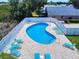 Aerial shot showcasing the kidney-shaped pool, surrounded by lounge chairs, for outdoor relaxation and enjoyment at 1307 Wayne Ave, New Smyrna Beach, FL 32168