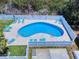 Aerial view of a fenced in kidney-shaped pool with several lounge chairs for relaxing and enjoying the Florida weather at 1307 Wayne Ave, New Smyrna Beach, FL 32168
