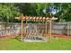 Backyard with pergola swing set surrounded by lush green grass and mature trees at 135 12Th St, Daytona Beach, FL 32117