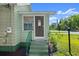Charming front entrance with freshly painted stairs and teal handrail leading to a quaint front door at 135 12Th St, Daytona Beach, FL 32117