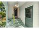 Charming front porch with green painted stairs and a door, enhanced by surrounding greenery at 135 12Th St, Daytona Beach, FL 32117