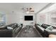 Bright living room with two gray leather sofas, large windows, and ceiling fan at 135 12Th St, Daytona Beach, FL 32117