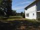 Spacious backyard with a view of the side of the home and neighboring properties at 1627 Umbrella Tree Dr, Edgewater, FL 32132