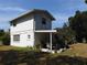 Exterior shot of the back of the house, including a covered patio and outdoor seating area at 1627 Umbrella Tree Dr, Edgewater, FL 32132