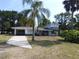Charming two-story home featuring a carport, upper balcony, and lush landscaping at 1627 Umbrella Tree Dr, Edgewater, FL 32132