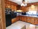 Eat-in kitchen featuring knotty wood cabinets, black appliances, tile floor, and ceiling fan at 1627 Umbrella Tree Dr, Edgewater, FL 32132