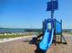 A blue playground with a slide provides a safe space for children to play by the water at 1627 Umbrella Tree Dr, Edgewater, FL 32132