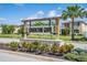 Cornerstone Grove community sign featuring stone base, wooden pergola, professional landscaping, and palm tree at 1674 Coulter Ln, Port Orange, FL 32129