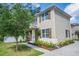 Two-story home with shutters, neutral colors, mature landscaping, a sidewalk, and a charming front porch at 1674 Coulter Ln, Port Orange, FL 32129