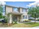 Two-story home featuring tidy landscaping, neutral colors, and a charming front porch with decorative columns at 1674 Coulter Ln, Port Orange, FL 32129