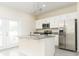 Bright kitchen showcasing stainless steel appliances, granite countertops, a functional island, and ample cabinet space at 1674 Coulter Ln, Port Orange, FL 32129
