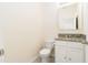 Compact powder room featuring granite countertop and white cabinetry at 1674 Coulter Ln, Port Orange, FL 32129