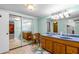 Bathroom with double sink vanity, tiled floor, and large mirror at 1786 Taylor Rd, Port Orange, FL 32128