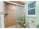 Bathroom featuring tiled shower stall with bench, glass door and accent tile, plus a frosted window at 1786 Taylor Rd, Port Orange, FL 32128