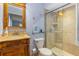 Cozy bathroom featuring a vanity with a mirror and a glass-enclosed shower with beige tile at 1786 Taylor Rd, Port Orange, FL 32128