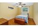 Well-lit bedroom with wood floors, and a window dressed in white sheer curtains at 1786 Taylor Rd, Port Orange, FL 32128