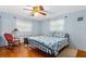 Charming bedroom with wood floors, ceiling fan, and a bed dressed in blue seashell-themed bedding at 1786 Taylor Rd, Port Orange, FL 32128