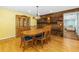 Dining room with hardwood floors, vintage chandelier, wood paneling, and seating for eight at 1786 Taylor Rd, Port Orange, FL 32128