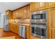 Modern kitchen featuring stainless steel appliances, wood cabinets, and tile backsplash at 1786 Taylor Rd, Port Orange, FL 32128