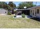 View of a screened-in patio and spacious backyard with mature trees and lawn at 1830 Needle Palm Dr, Edgewater, FL 32132