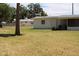 View of the backyard, including lush green grass and views of the home at 1830 Needle Palm Dr, Edgewater, FL 32132