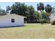 View of the backyard, detached garage, and well-maintained lawn at 1830 Needle Palm Dr, Edgewater, FL 32132