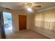 This bedroom features neutral carpet, a ceiling fan and window with light filtering curtains at 1830 Needle Palm Dr, Edgewater, FL 32132