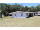 Ranch-style home with a large lawn, and mature trees offering shade at 1830 Needle Palm Dr, Edgewater, FL 32132