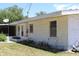Rear exterior view of home showcasing the brick architecture and garden beds at 1830 Needle Palm Dr, Edgewater, FL 32132