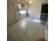 Functional kitchen area with tile flooring, a window, and an adjacent doorway that offers practicality at 1830 Needle Palm Dr, Edgewater, FL 32132