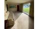 Living room featuring neutral carpet, a large window, and a floral sofa at 1830 Needle Palm Dr, Edgewater, FL 32132