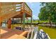 Waterfront dock with boat lift and personal watercraft, with stairs to an upper deck and pool nearby at 184 Azalea Rd, Edgewater, FL 32141
