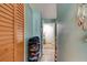 Hallway featuring a shoe rack, closet, and doorway at the end, enhanced by serene turquoise walls at 184 Azalea Rd, Edgewater, FL 32141