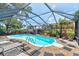 Enclosed screened pool area with comfortable lounge chairs, stone accents, and well-manicured landscaping at 184 Azalea Rd, Edgewater, FL 32141