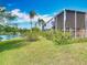 Scenic backyard view with a pond, lush green lawn, and mature palm trees at 1840 Tara Marie Ln, Port Orange, FL 32128