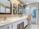 Bathroom featuring a double vanity, framed mirrors, a walk-in shower, and updated fixtures at 1840 Tara Marie Ln, Port Orange, FL 32128