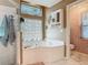 Bright bathroom with a soaking tub, glass block window, and separate shower stall at 1840 Tara Marie Ln, Port Orange, FL 32128
