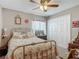 Well-lit bedroom featuring a ceiling fan, double door closet, and a floral comforter at 1840 Tara Marie Ln, Port Orange, FL 32128