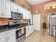 Modern kitchen features white cabinets, stainless steel appliances, and an adjacent dining area at 1840 Tara Marie Ln, Port Orange, FL 32128