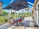Inviting screened lanai with a table and chairs, perfect for outdoor dining by the water at 1840 Tara Marie Ln, Port Orange, FL 32128