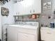 Well-organized laundry room with white washer, dryer, sink, and overhead storage cabinets at 1840 Tara Marie Ln, Port Orange, FL 32128