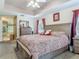 Bedroom with a large bed, wooden furniture, ceiling fan, trey ceiling, and ensuite bathroom at 1840 Tara Marie Ln, Port Orange, FL 32128