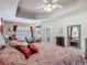 Spacious bedroom featuring a tray ceiling, ceiling fan, and views of the backyard at 1840 Tara Marie Ln, Port Orange, FL 32128