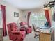 Sitting area in the main bedroom with red upholstered chairs, side table, and window at 1840 Tara Marie Ln, Port Orange, FL 32128