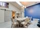 Cozy dining room with a long table, chandelier, and barn door, next to a blue accent wall at 1903 Sprucewood Way, Port Orange, FL 32128