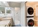 Functional bathroom and laundry area with granite countertops, vanity, stackable washer/dryer and closet at 1903 Sprucewood Way, Port Orange, FL 32128